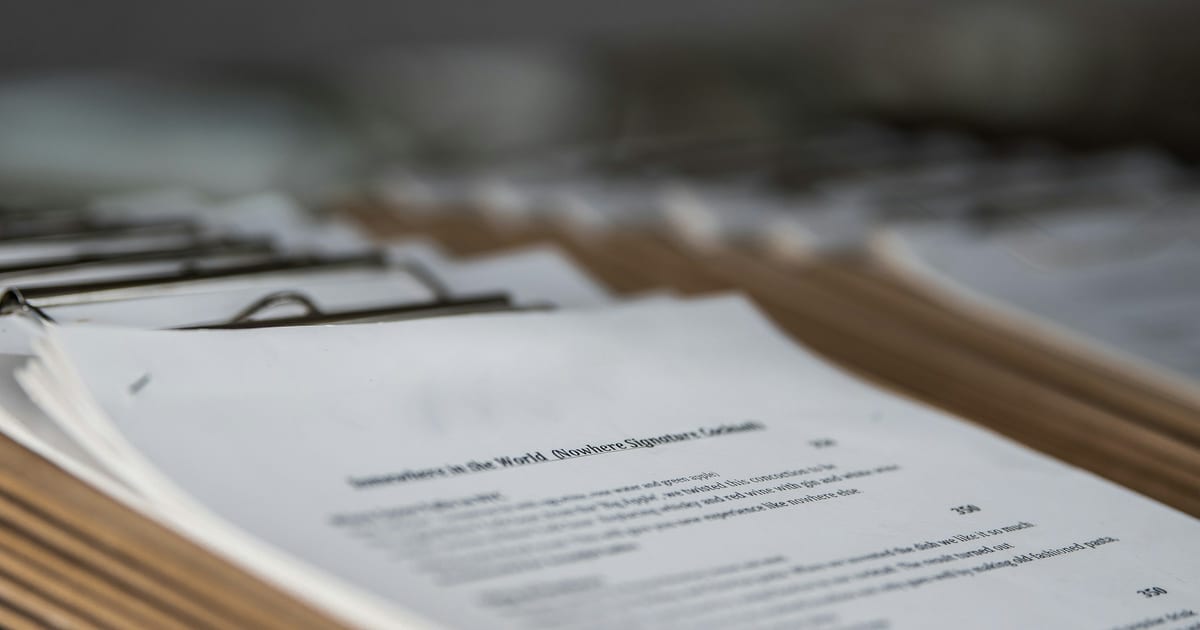 A close-up of printed pages of dense text lying on a desk